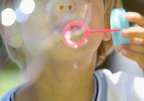 Boy blowing bubbles --- Image by © Royalty-Free/Corbis A child blowing bubbles outdoors on a sunny day.