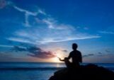 mar12-meditate Silhouette of a person meditating at sunset by the ocean.